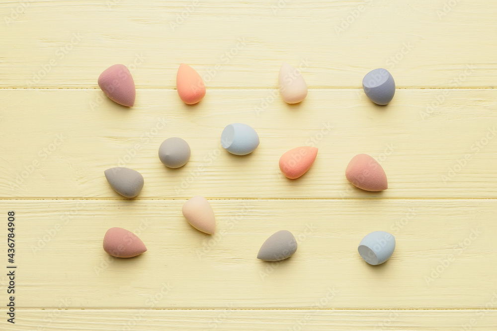 Makeup sponges on color wooden background