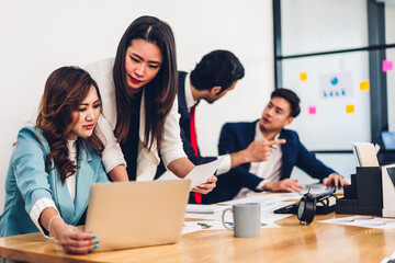 Group of professional asian business meeting and discussing strategy with new startup project.Creative business people planning and brainstorm with laptop computer in modern office.Teamwork concept