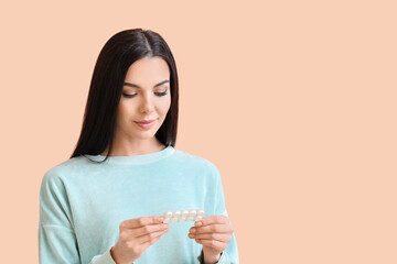 Wall Mural - Beautiful young woman with pills on color background