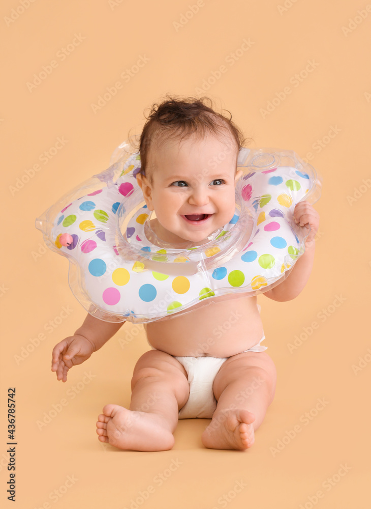 Cute baby with inflatable ring on color background