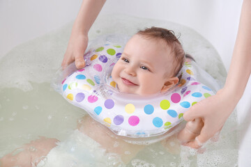 Canvas Print - Mother and cute baby with inflatable ring in bathroom