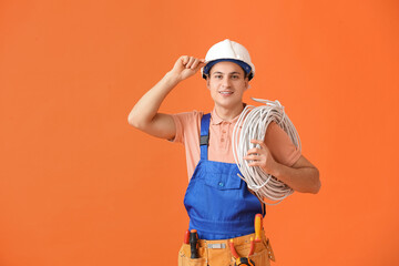 Sticker - Young electrician with cables on color background