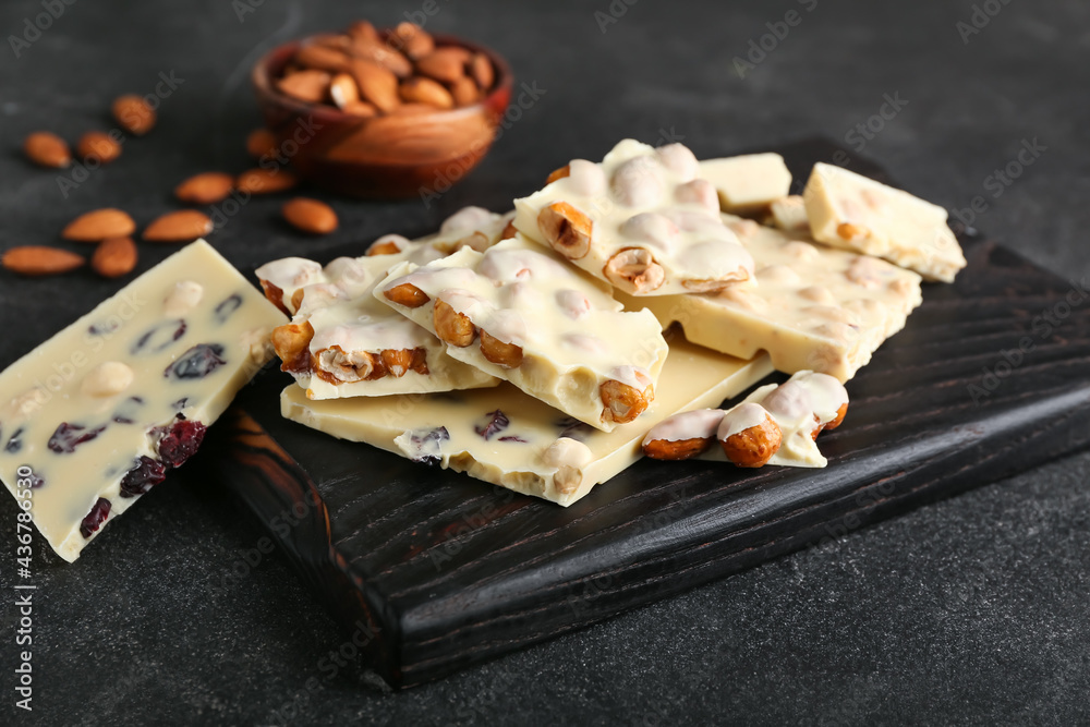 Composition with sweet white chocolate and nuts on dark background