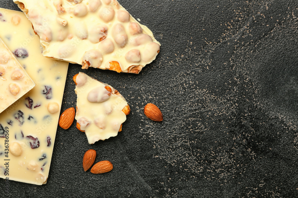 Tasty white chocolate with nuts on dark background