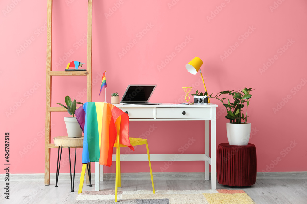 Modern workplace with flag of LGBT hanging on chair - obrazy, fototapety, plakaty 