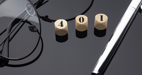 401 concept, words on wooden blocks on the black background with pen and glasses.