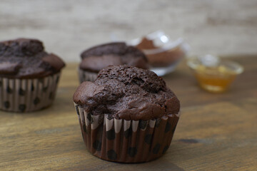 Canvas Print - Closeup shot of delicious chocolate muffins on a wooden table