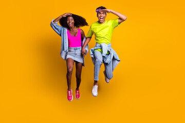 Canvas Print - Full length body size view of handsome beautiful trendy cheery couple jumping searching find isolated on bright yellow color background