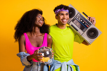 Poster - Photo of funky pretty young couple dressed denim outfit dancing holding boom box disco ball isolated yellow color background