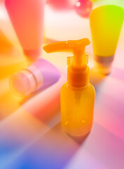 Wall Mural - Cosmetic product creative still life. Colorful Cosmetic package collection on abstract spectrum neon  background. Beauty care concept.
