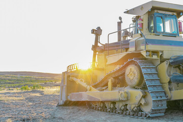 heavy machinery. large tractor excavator bulldozer on a construction site with sunset in the background