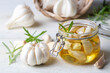Fresh garlic and garlic oil on the wooden background