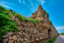 Abandoned And Brownfield Ancient City Walls In Iznik Bursa Made Of Red Bricks Wall Covered By Green Plants And Grass With Blue Sky Background Established By Byzantine Empire