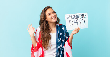 Wall Mural - young pretty woman smiling happily, waving hand, welcoming and greeting you independence day concept