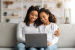 © Prostock-studio - Happy african american mother and daughter using laptop together