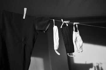 Grayscale shot of laundry and masks hanging on a line