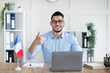 © Prostock-studio - Online French lesson. Foreign languages tutor teaching class on web, using laptop pc, showing thumb up at home office