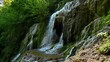 Video with a beautiful waterfall in green spring forest, Krushuna falls, Balkan Mountains, Bulgaria..
