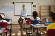 © Wavebreak Media - Portrait of caucasian male teacher teaching diverse group of students in class at elementary school