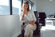 © Wavebreak Media - Smiling caucasian businesswoman sitting at desk at work