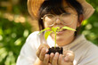 © Wavebreak Media - Smiling asian girl wearing glasses and straw hat, holding plant in garden