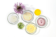 Laboratory Petri Dishes With Onions, Oil, Lemon, Aloe Vera And Onion Flower Head Isolated On White Background.