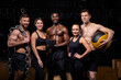 © Roman - multi-ethnic people posing at camera with sportive equipment for cross fit training. beautiful shirtless male athletes and women in top and leggins looking at camera