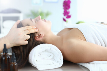 Young woman doing head massage in spa center