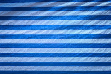 PVC canvas shade sheet in blue color stripted, general material using to barricade the construction area. Background and texture close-up photo.