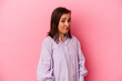 © Asier - Middle age caucasian woman isolated on pink background shrugs shoulders and open eyes confused.