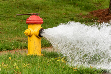 An Suburban Fire Hydrant That Has Been Opened Letting Water Freely Flow.