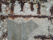 Closeup of an old deteriorated, chipped wall with exposed iron bars