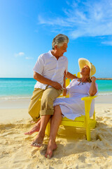 Wall Mural - Older couple at the beach and sitting on beach chairs