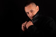 © blanke1973 - a young handsome man wears a black coat on a black background