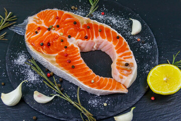 Wall Mural - Raw salmon steak with spices on black slate