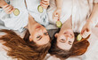 © Daria Lukoiko - Two girls make homemade face and hair beauty masks. Cucumbers for the freshness of the skin around the eyes. Women take care of youthful skin. Girlfriends laugh at home lying on the floor on pillows.