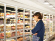 © lado2016 - Man choosing frozen food from a supermarket freezer.
