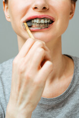 Wall Mural - Woman with healthy white teeth holds a toothbrush and smiles. Oral hygiene concept