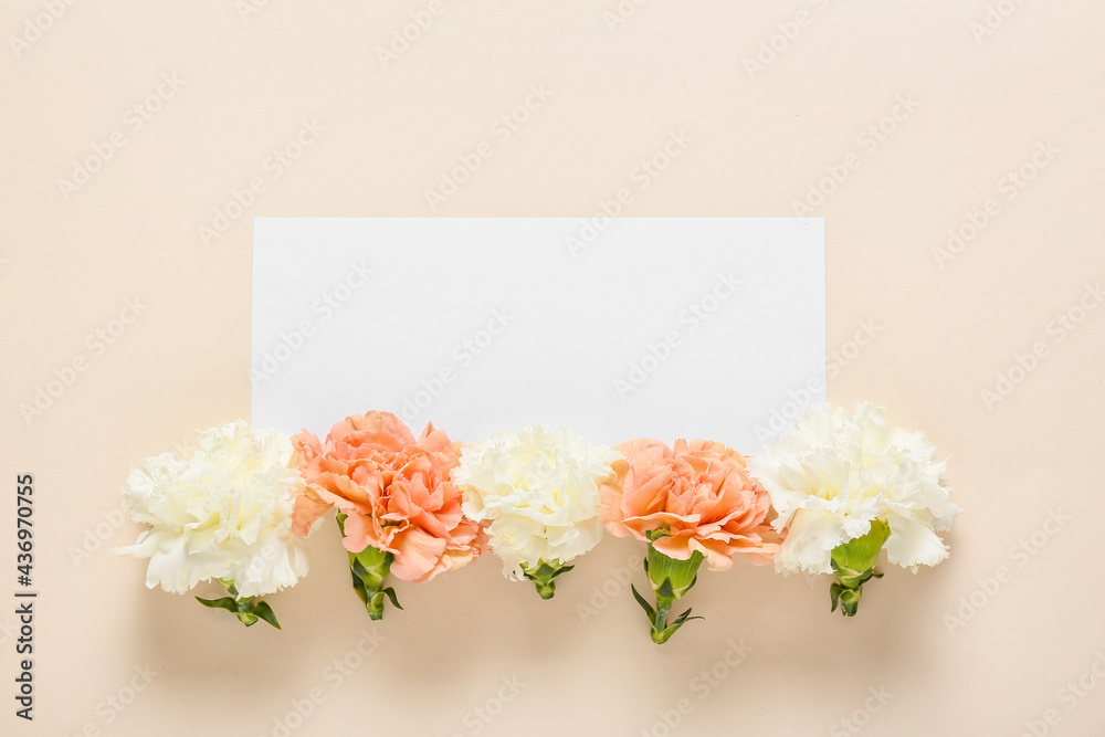 Beautiful carnation flowers and blank card on color background