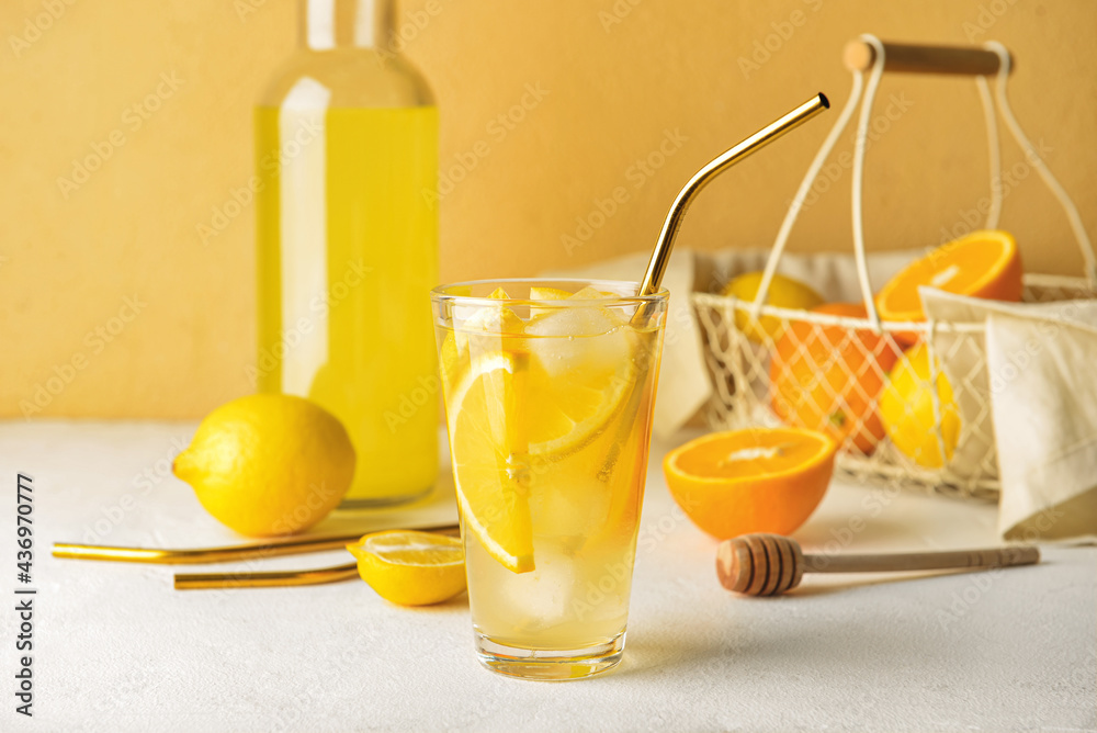 Composition with tasty cold lemonade and citrus fruits on color background
