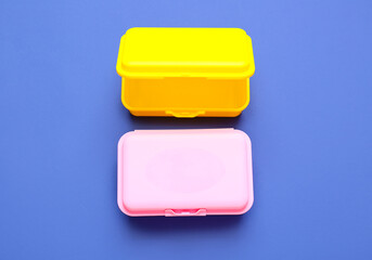 Plastic lunch boxes on color background