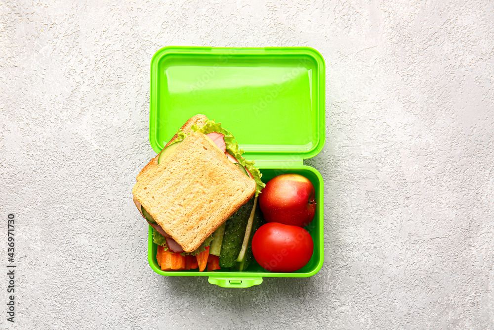 Lunch box with tasty food on light background
