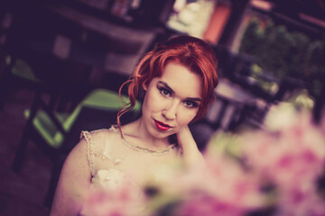 Poster - Caucasian female with red hair posing at a cafe