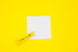 Blank white To Do List Sticker with yellow wooden clothespin. Close up of reminder note paper on the yellow background. Copy space. Minimalism, original and creative photo.