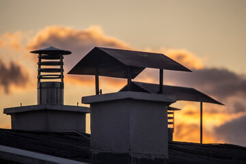 Wall Mural - various chimneys against the sky. red sky.