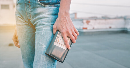 Female hands are holding a wallet with US dollars. The concept of finance, savings, financial expenses. Close-up. WEB banner format shot. Copy space