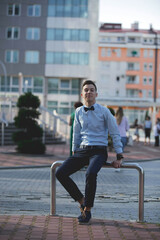 Wall Mural - Young handsome elegant man in a shirt and a bow posing outdoors