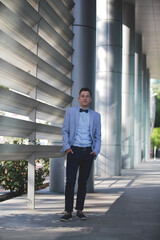 Poster - Young handsome elegant man in a blue suit and bow posing outdoors