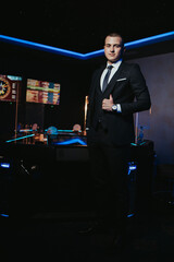 Wall Mural - Vertical shot of a handsome Caucasian male with a suit posing at a club