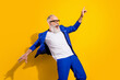 Photo of crazy happy cheerful old man look empty space wind fly blazer wear glasses isolated on yellow color background